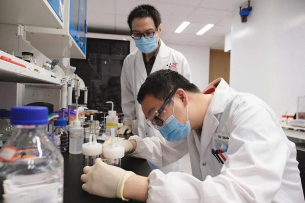 Giáo sư Alex Yan (đứng) cùng một đồng nghiệp đang nghiên cứu quá trình sản xuất phân urê trong phòng thí nghiệm tại Đại học Công nghệ Nanyang Singapore. Ảnh: NTU.
