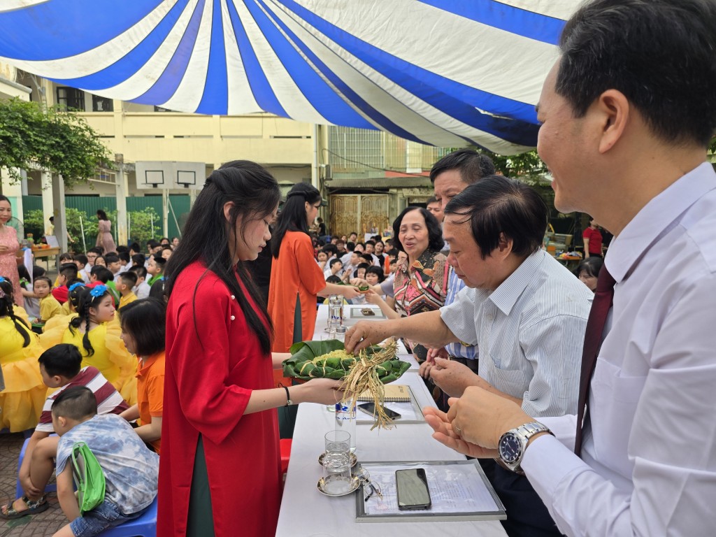 Thức quà nổi tiếng của Hà Nội: Cốm Làng Vòng được học sinh mời đại biểu và khán giả thưởng thức Thức quà nổi tiếng của Hà Nội: Cốm Làng Vòng được học sinh mời đại biểu và khán giả thưởng thức