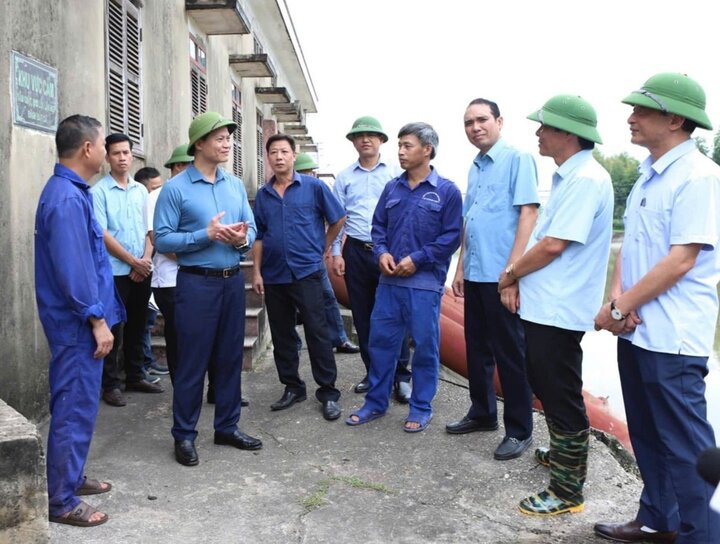 Chủ tịch UBND tỉnh Bắc Ninh Vương Quốc Tuấn (thứ 2, hàng thứ nhất từ trái sang) trò chuyện, động viên công nhân đang làm việc tại trạm bơm Trúc Tay. Ảnh: Nguyễn Miền.