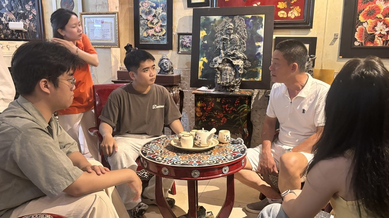 Các bạn trẻ thuộc dự án Lam Ấn Ký lắng nghe nghệ nhân Đỗ Hữu Triết (áo trắng, bên phải) chia sẻ kinh nghiệm gìn giữ và phát triển di sản. Ảnh: Nguyễn Ngọc.