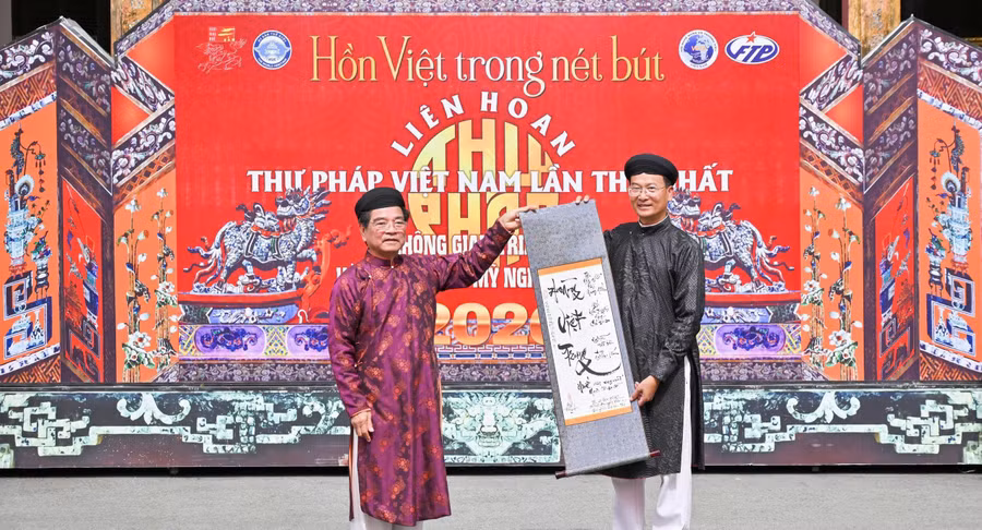 TS Lê Ngọc Dũng, Chủ tịch Hội Nghệ nhân và Thương hiệu Việt Nam (trái) trao tặng bức thư pháp cho ông Hoàng Việt Trung, Giám đốc Trung tâm Bảo tồn Di tích Cố đô Huế. z8403010592083-314b1fe47cfd8f5e2c59fe97f14ace7c.jpg